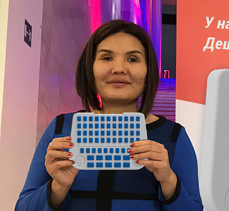 Женщина держит самоучитель Брайля SEZUAL